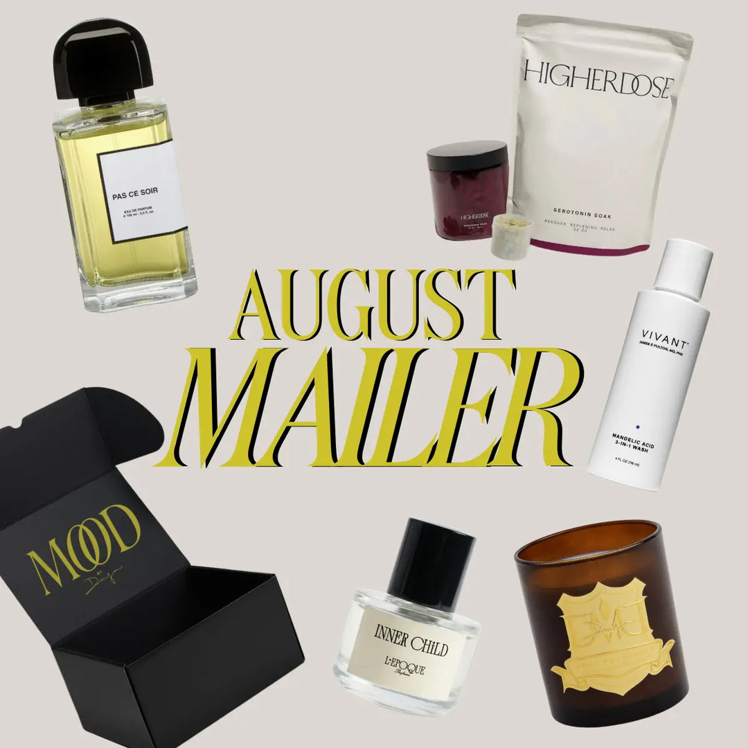 August Mood Mailer box flatlay featuring DMJ Home Fragrance Pillow Talk candle, Higher Dose Serotonin Bath Soak, BDK Parfums and L'Epoque Parfums niche perfume samples, and Alair Med Spa Vivant Mandelic Acid 3-in-1 Wash