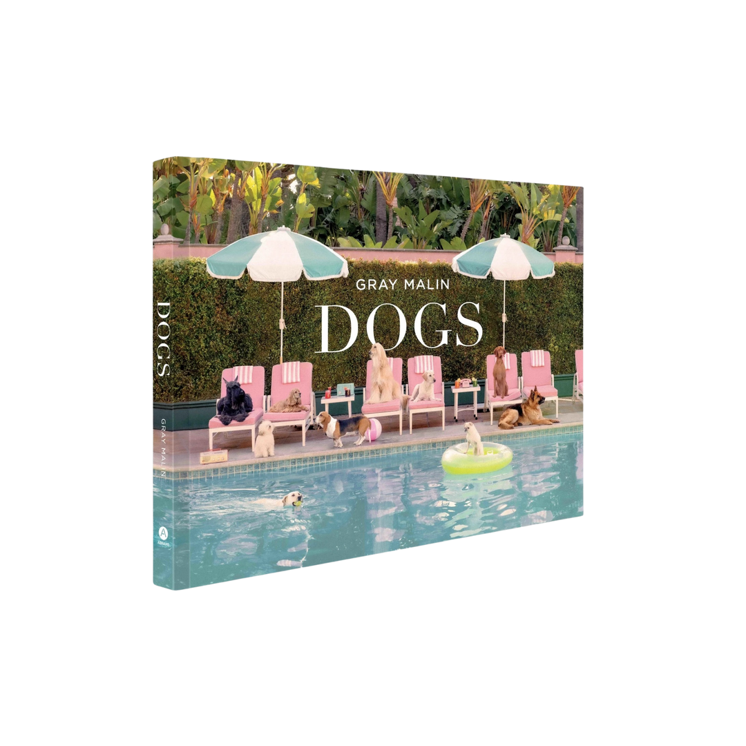 Dogs by Gray Malin coffee table book featuring dogs lounging poolside with pastel umbrellas and luxury resort setting