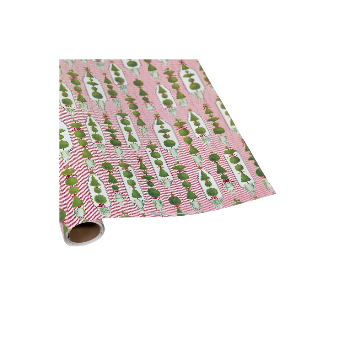 Red and green wrapping paper roll with topiary trees and red bows on candy stripes
