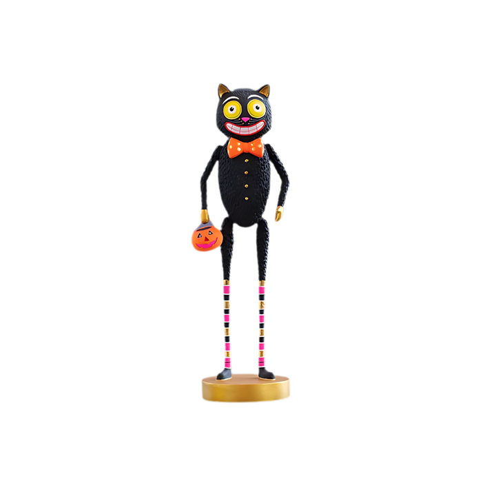 Twitchy. Halloween-themed black cat table top figurine with a pumpkin, colorful legs, and a bow tie on a white background. Glitterville at Mood by DMJ in Lafayette, LA.