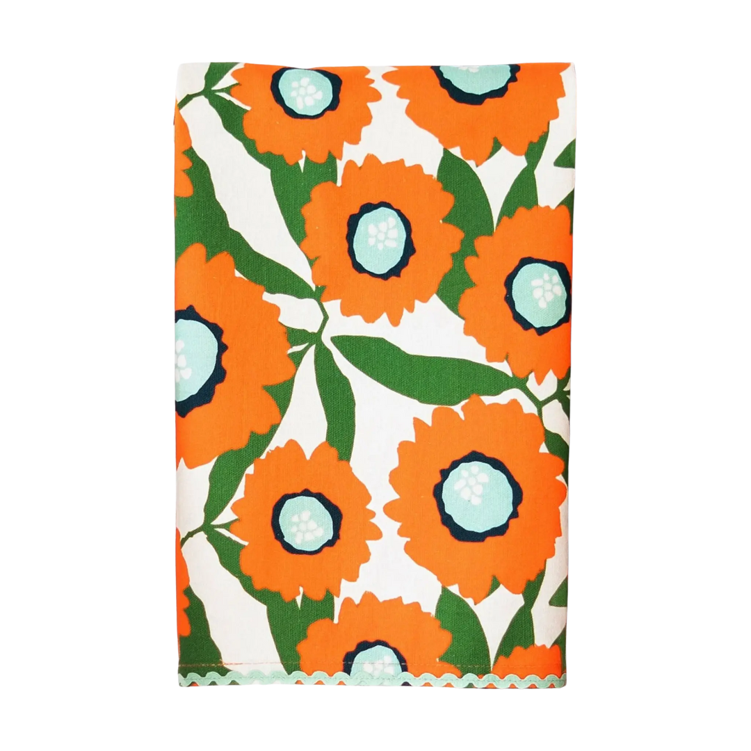 Petal Kitchen Towel with bold orange floral pattern and green leaves on white cotton with decorative trim