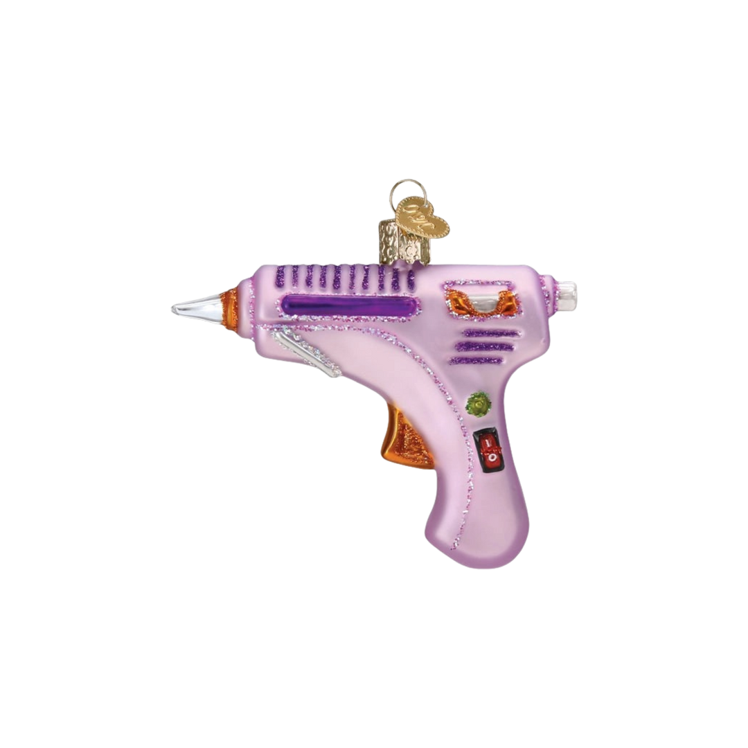 Hot Glue Gun glass ornament by Old World Christmas with silver and glitter accents hanging on a Christmas tree at Mood by DMJ in Louisiana.