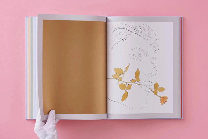Andy Warhol: Seven Illustrated Books by Taschen opened to a gold page and a line drawing of a face with a rose