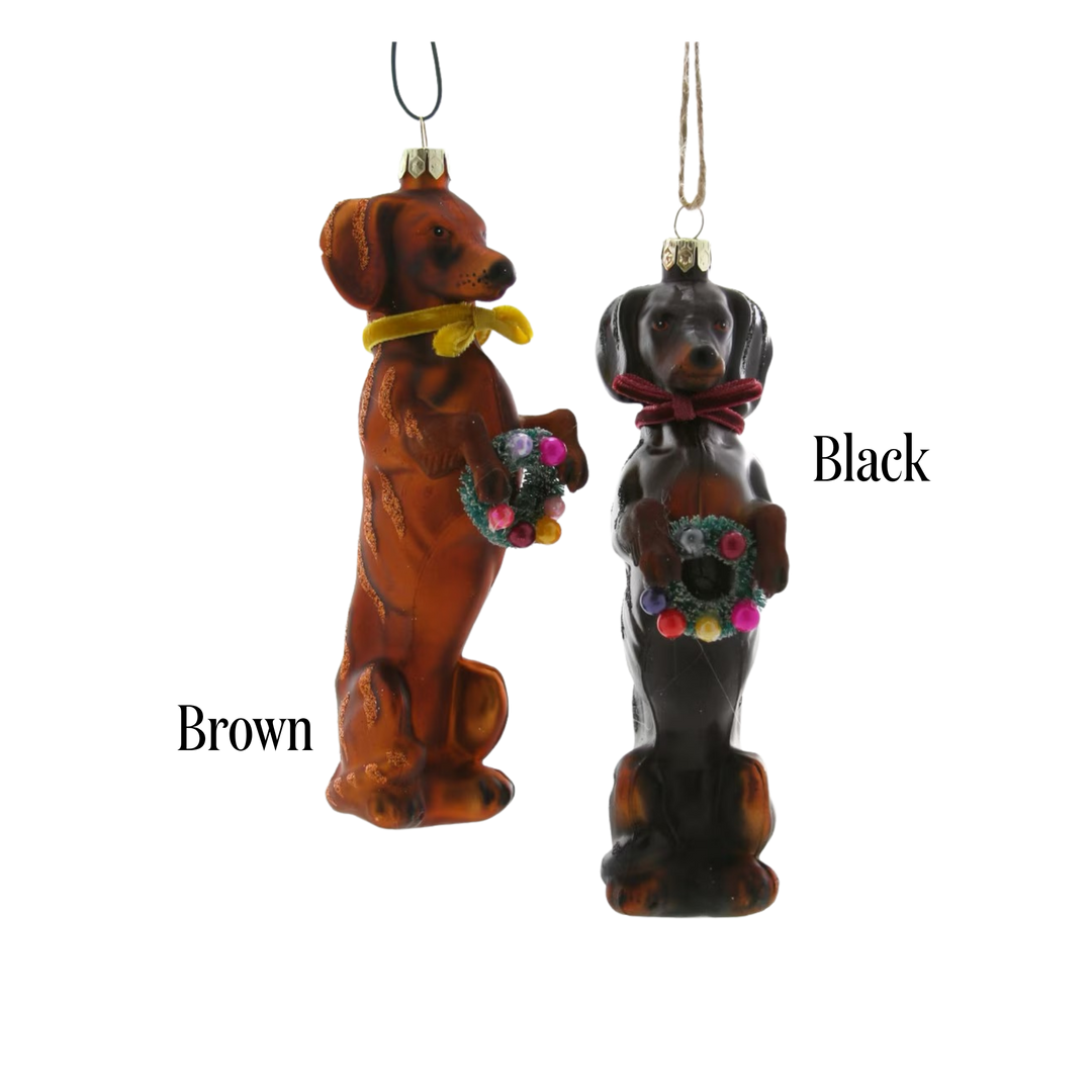Cody Foster festive doxy dachshund ornament color options, brown and black glass dachshunds in scarves holding wreaths, labeled