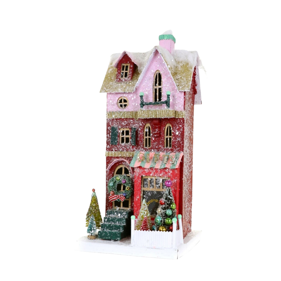 Cody Foster Gift Shop Christmas village house, tall glittered red and pink storefront with striped awning, wreath, and bottle brush trees