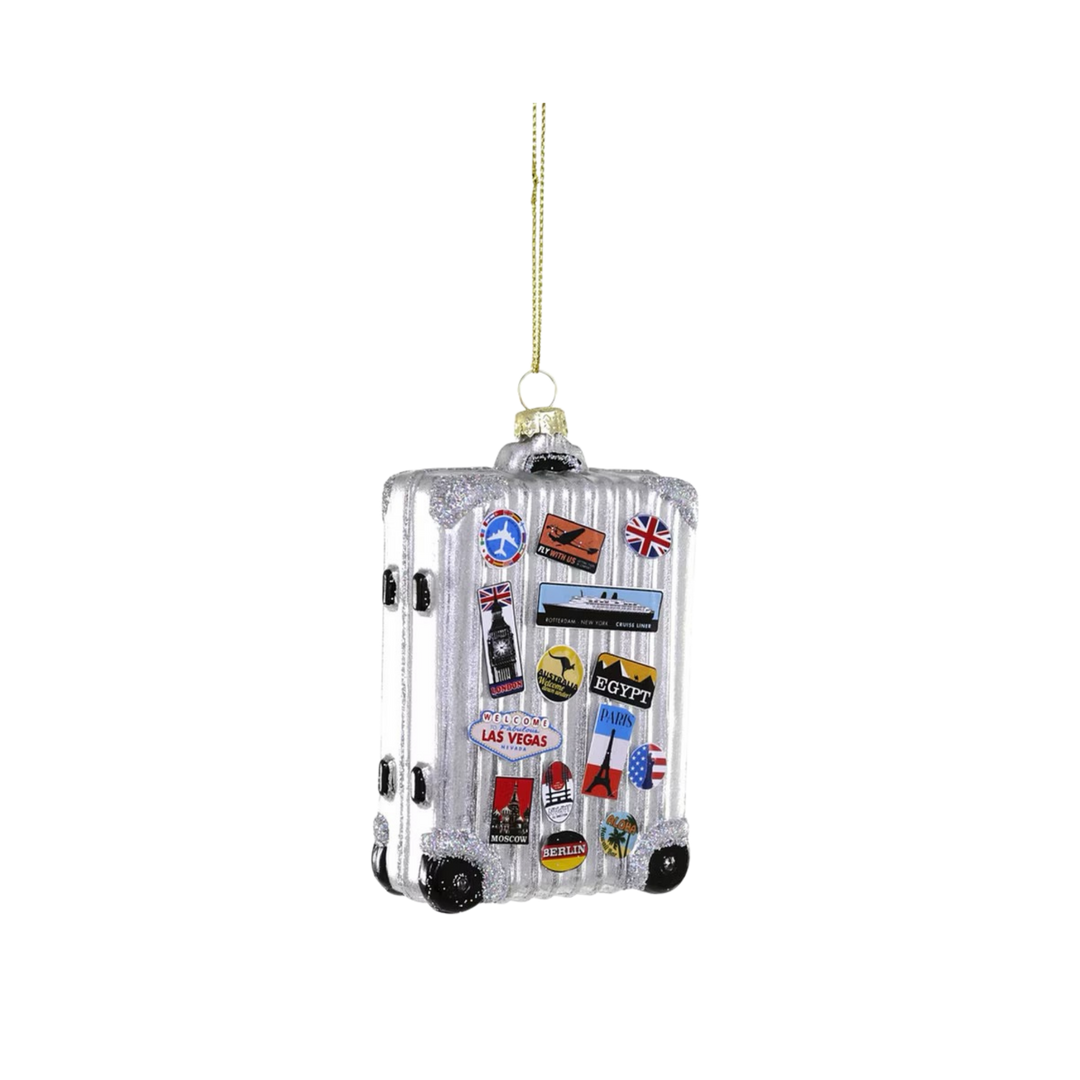 Cody Foster jetsetter glass Christmas ornament, silver suitcase covered in travel stickers with rolling wheels