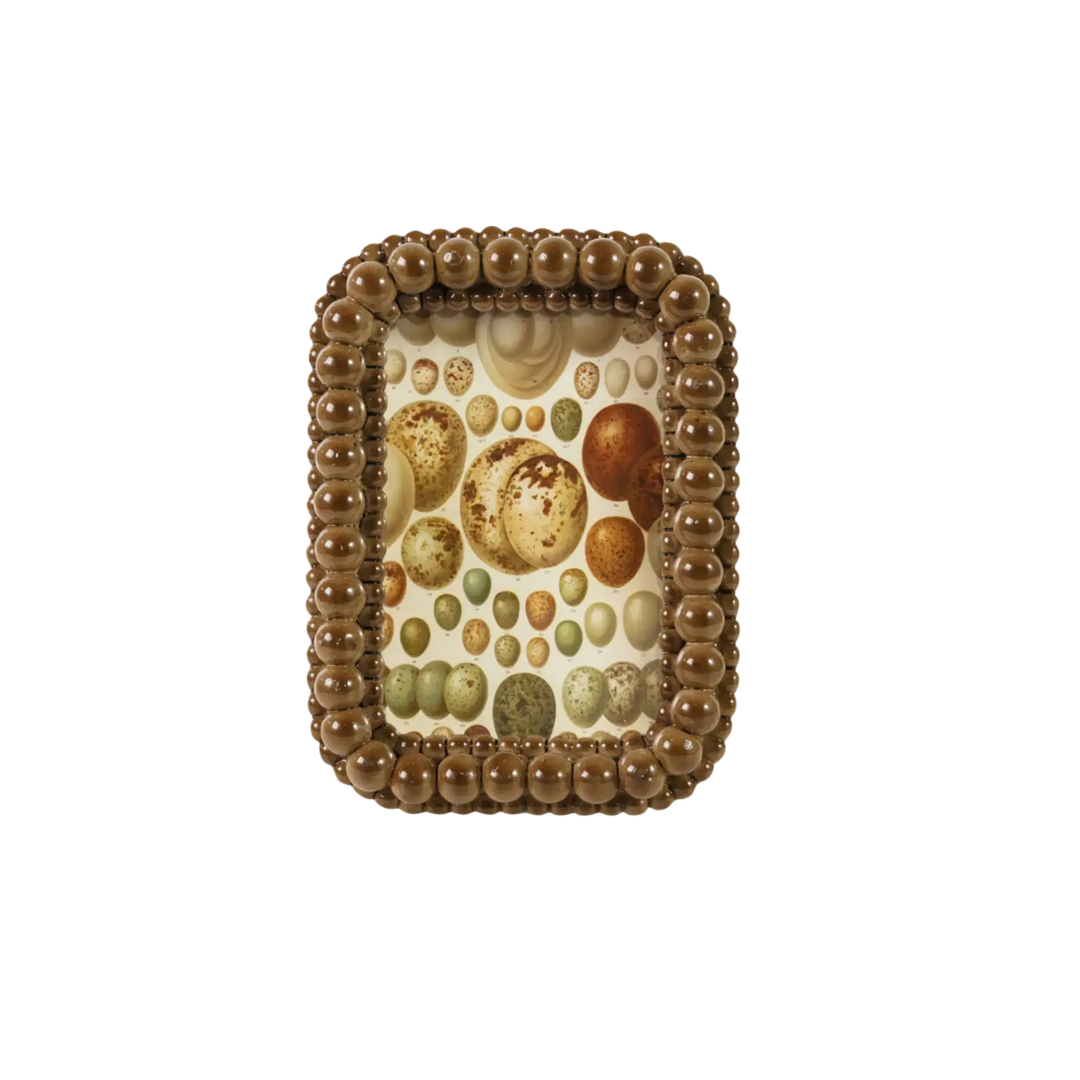 Brown bubble textured 4x6 photo frame with beaded border by Creative Co-Op, holding a decorative speckled egg print