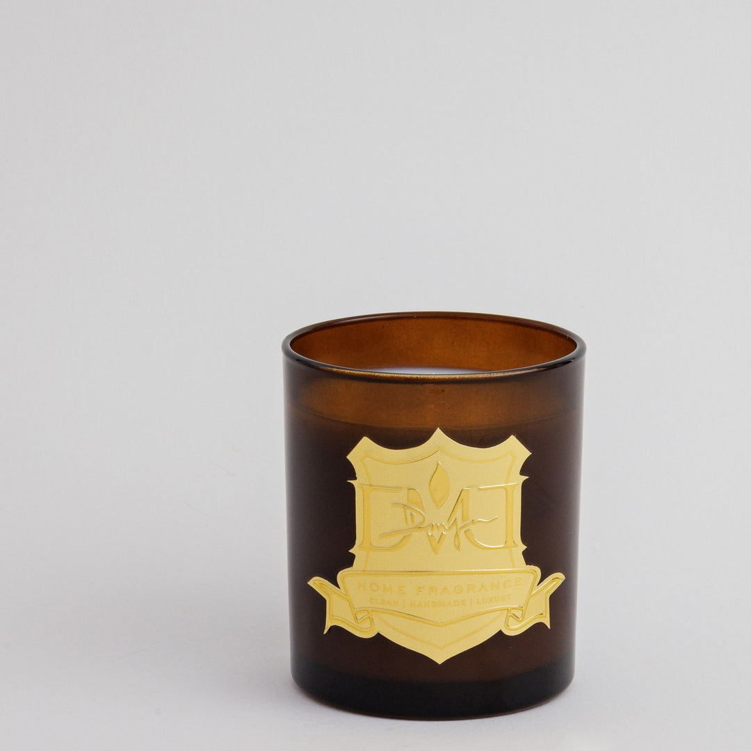 Earl Grey Candle by DMJ Home Fragrance, 12 oz coconut wax in dark amber glass with a gold crest label, on a light gray background
