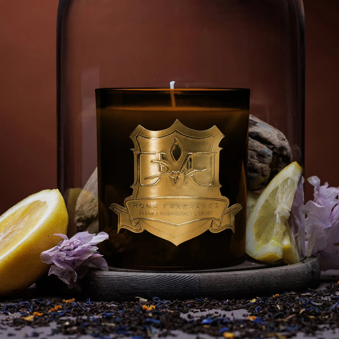 Earl Grey luxury black tea candle by DMJ Home Fragrance in signature glass vessel styled with lemon, dried florals, and loose tea leaves
