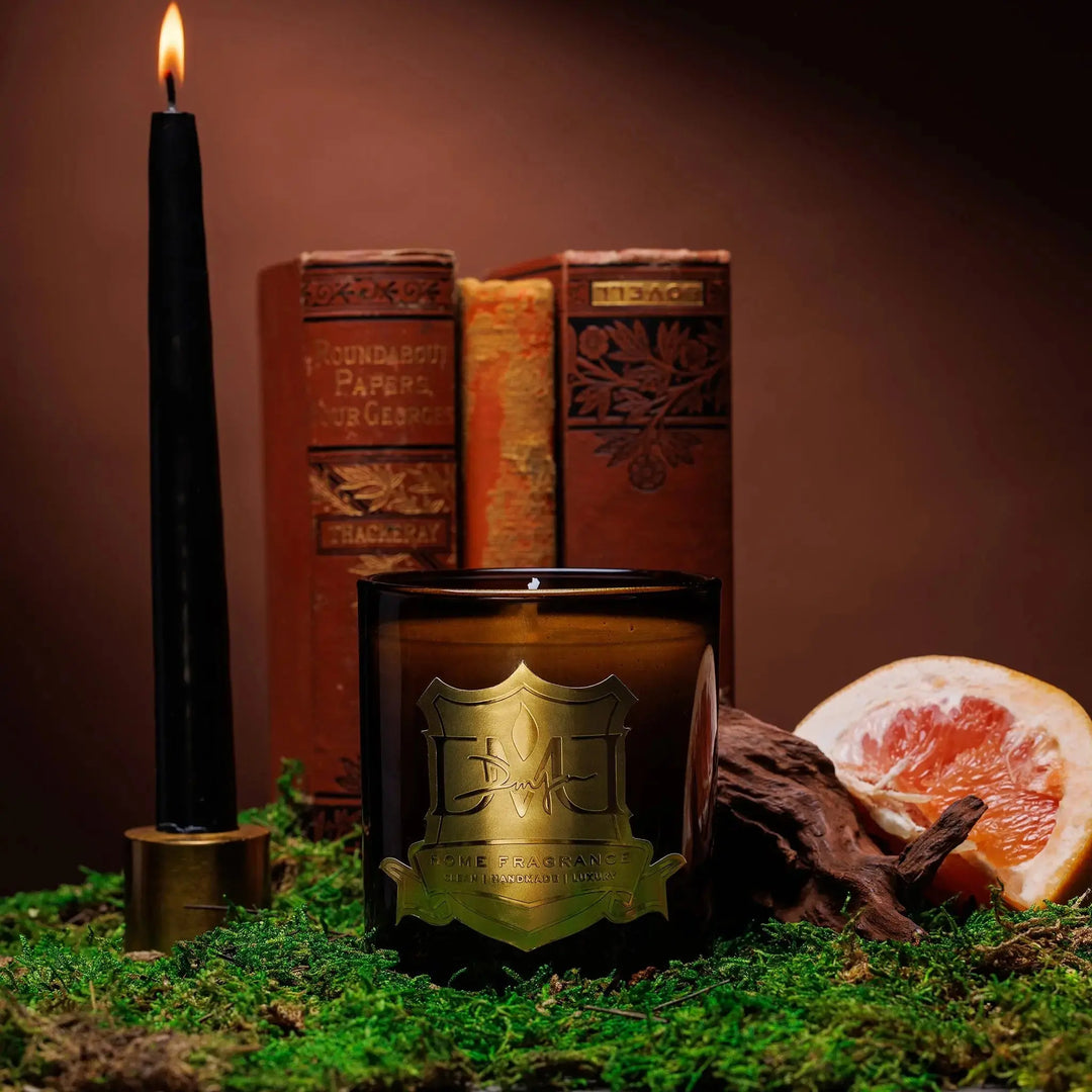 Hemingway luxury leather and tobacco candle by DMJ Home Fragrance in signature glass vessel styled with books and wood, hand-poured coconut