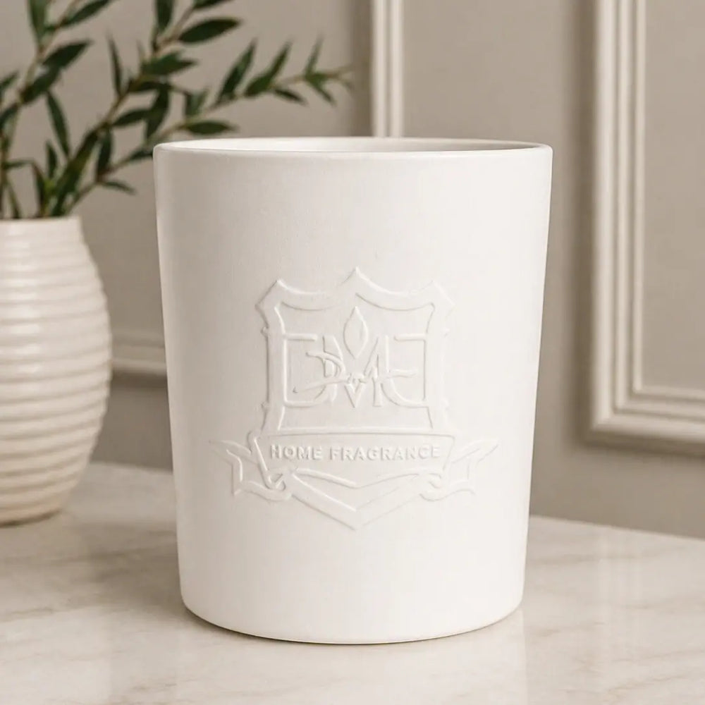 DMJ Home Fragrance Big Boy ceramic triple-wick candle styled on a marble surface with greenery and wall paneling