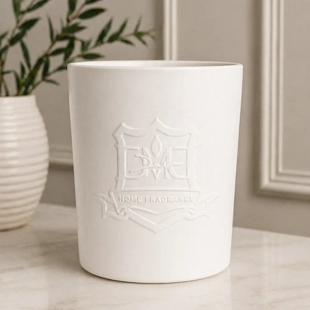 DMJ Home Fragrance Big Boy ceramic triple-wick candle styled on a marble surface with greenery and wall paneling