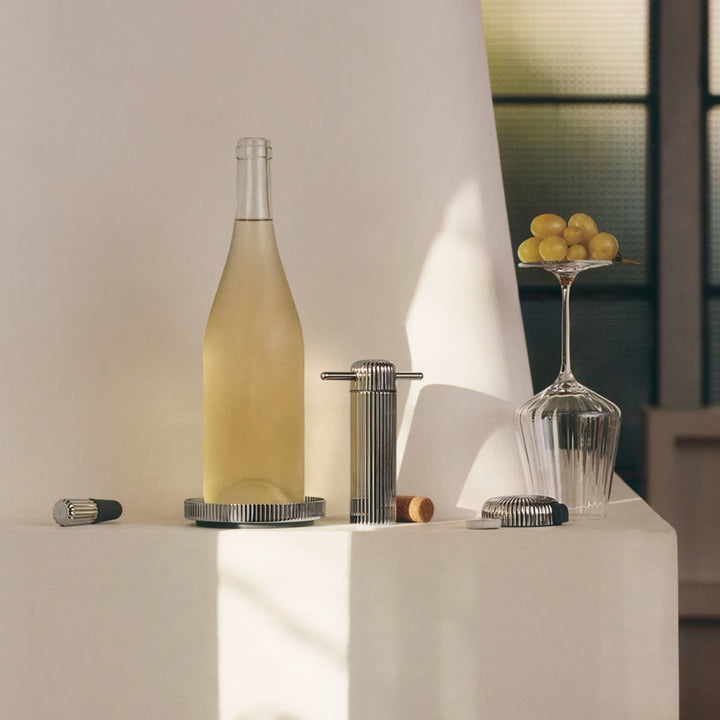 Georg Jensen Bernadotte stainless steel barware styled with a wine bottle and glass on a table