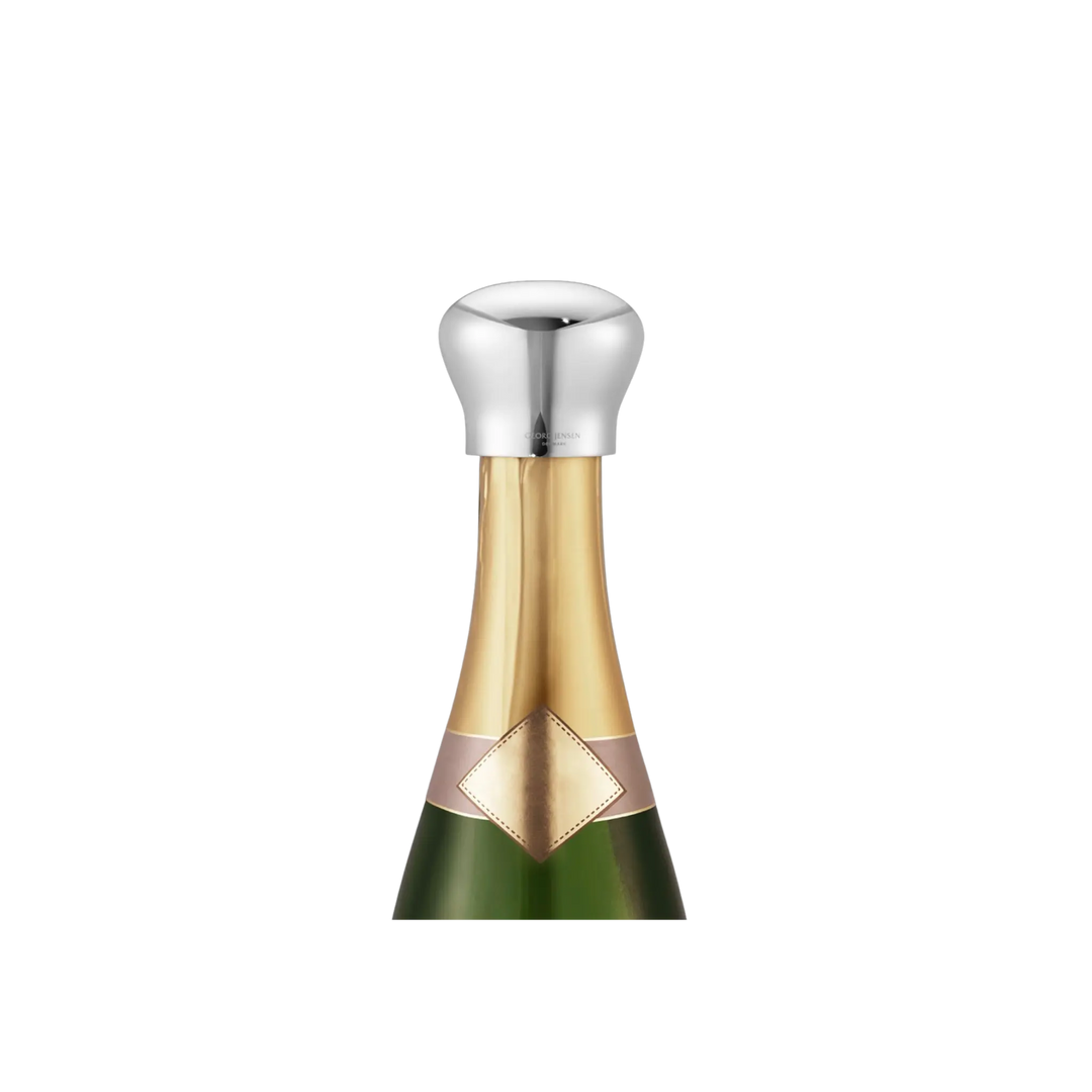 Georg Jensen Sky champagne bottle stopper in mirror-polished stainless steel sealing a champagne bottle