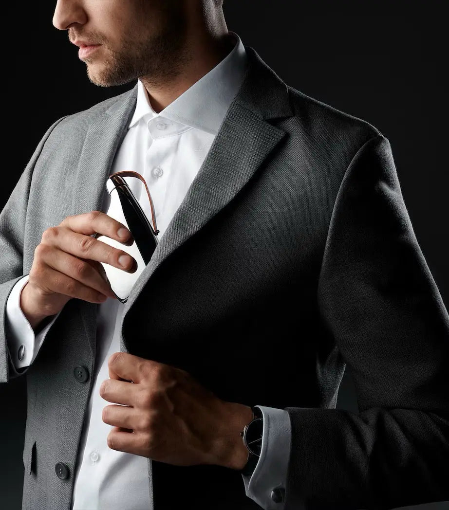 Man in a suit slipping the Georg Jensen Sky stainless steel hip flask into his jacket pocket