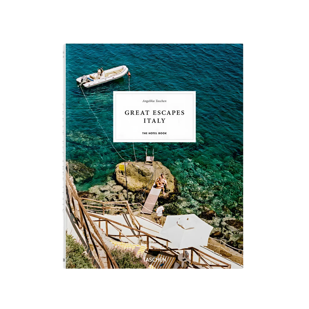 Great Escapes Italy. The Hotel Book by Angelika Taschen, cover of a boat on turquoise sea beside a rocky sun deck