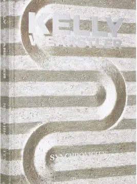 Close up of the Kelly Wearstler: Synchronicity cover with embossed silver lettering and carved stone pattern