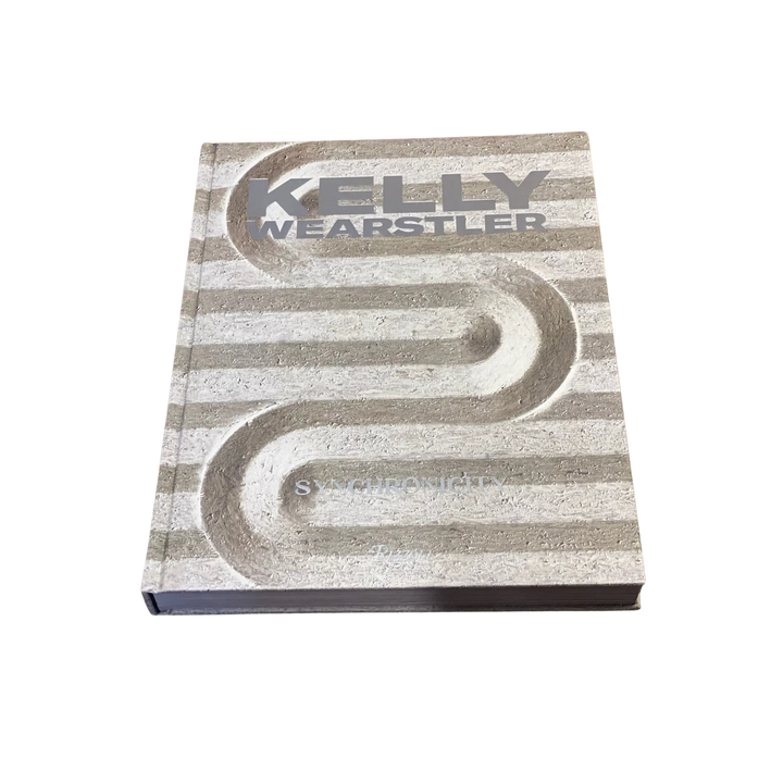 Front cover of Kelly Wearstler: Synchronicity, a Rizzoli interior design book with a striped stone relief design