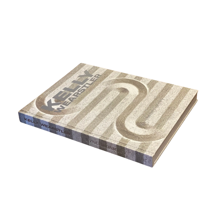 Kelly Wearstler: Synchronicity hardcover book by Rizzoli with a carved stone texture cover, shown flat