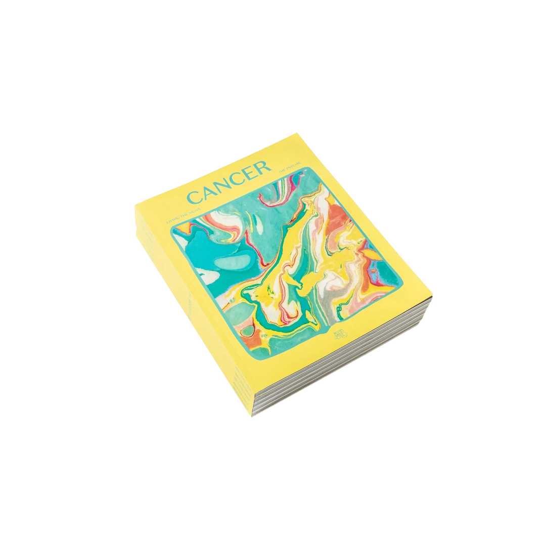 Living the Signs: Cancer astrology workbook by Britten LaRue, angled paperback with yellow marbled cover on black