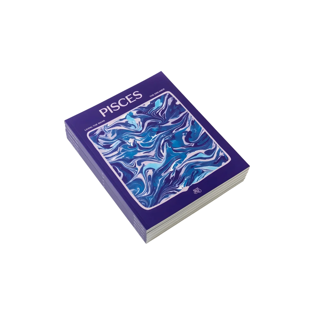 Living the Signs: Pisces astrology workbook by Britten LaRue, angled violet paperback with blue marbling on black