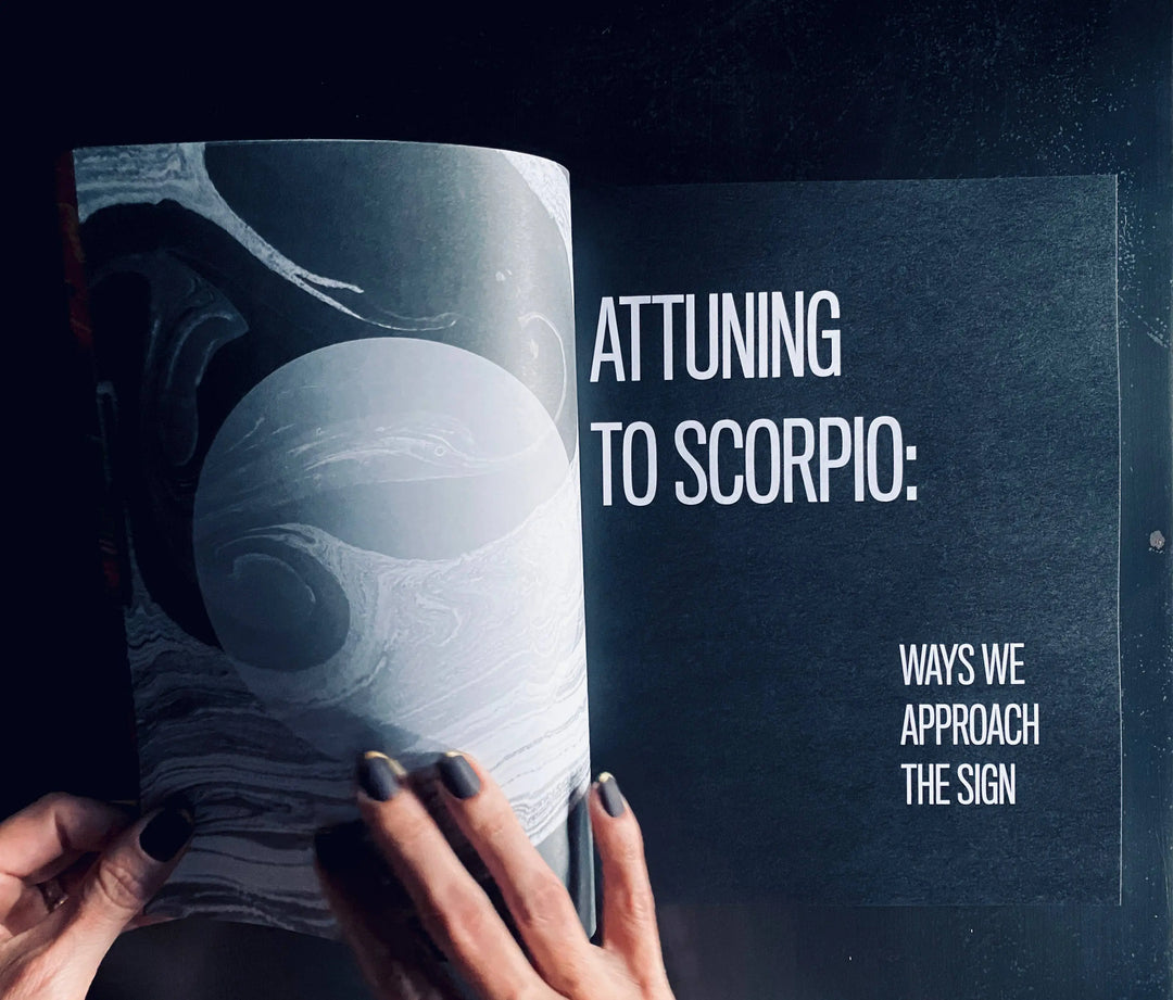 Living the Signs: Scorpio open to the Attuning to Scorpio chapter page with marbled art