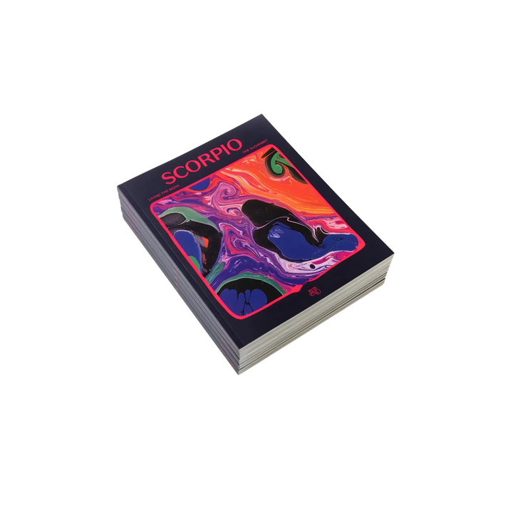 Living the Signs: Scorpio astrology workbook by Britten LaRue, angled navy paperback with pink marbling on black