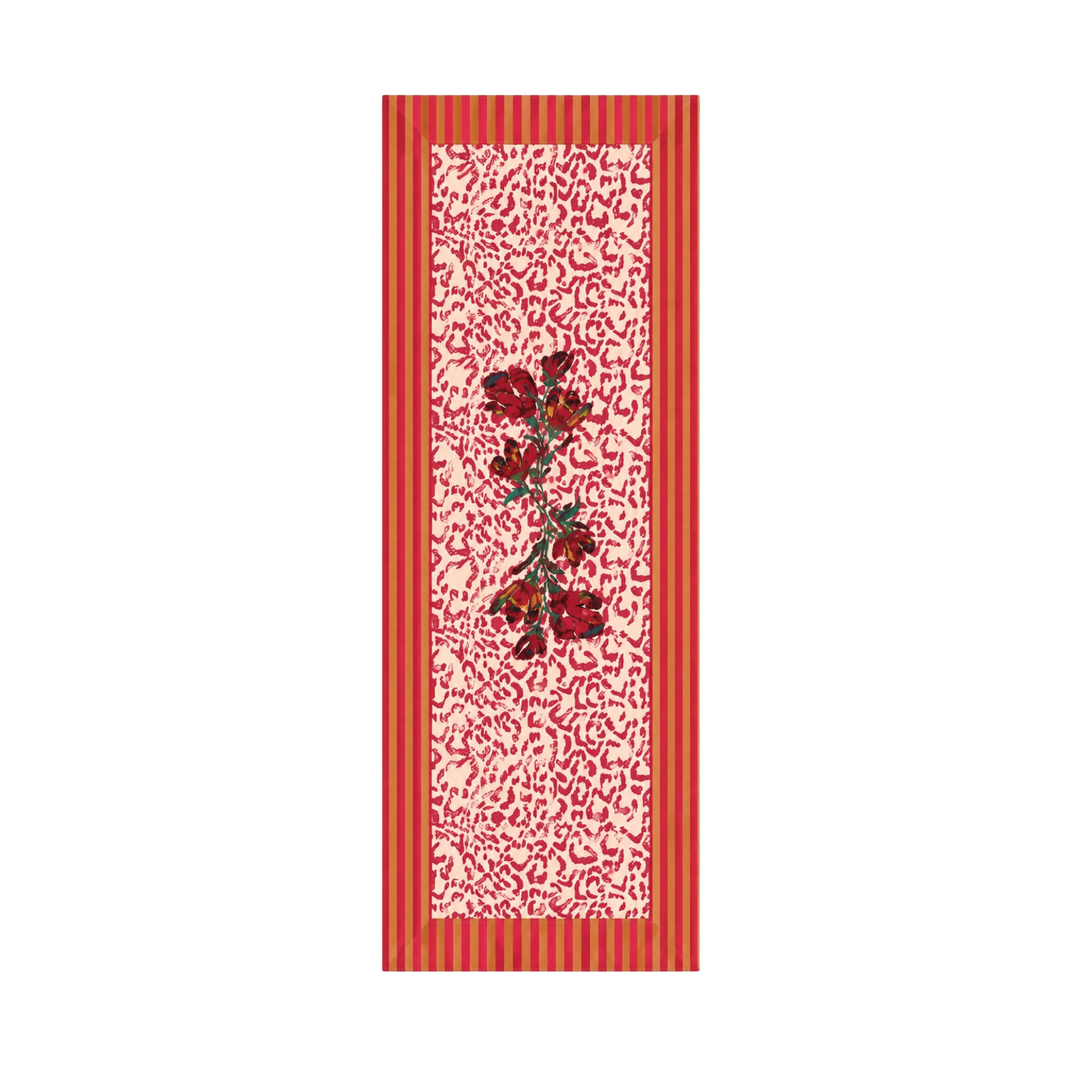 Coral red floral cotton table runner with a deep red rose spray on a cream scrollwork ground and coral striped edges.