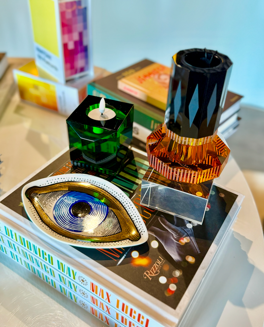 product display with crystal candle holders, eye dish, and coffee table books
