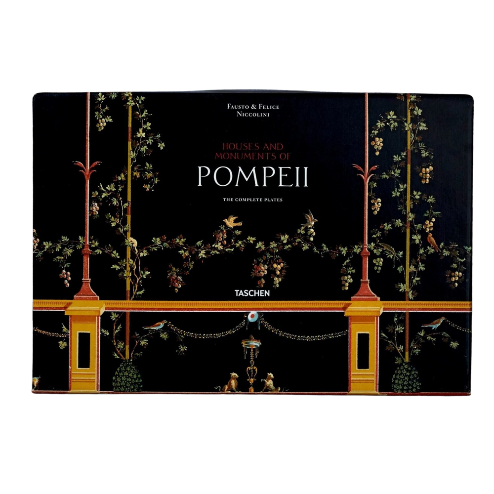 Houses and Monuments of Pompeii XXL book by TASCHEN, black Pompeian fresco cover with gold columns, garlands, and birds