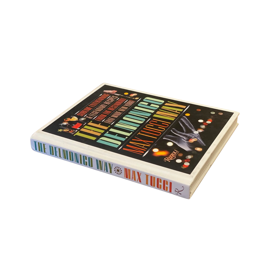 The Delmonico Way by Max Tucci from Rizzoli lying flat with its spine and colorful title showing